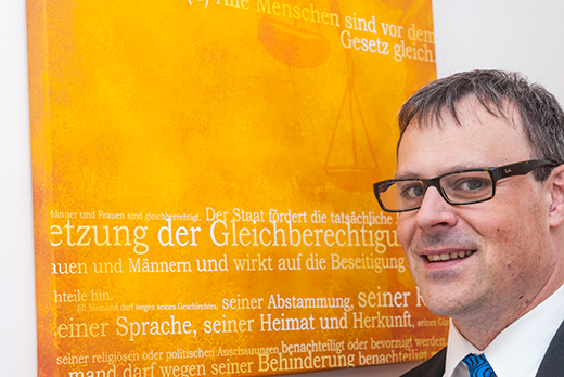 Rechtsanwalt Jürgen Faltermeier vor einem Justizmotiv